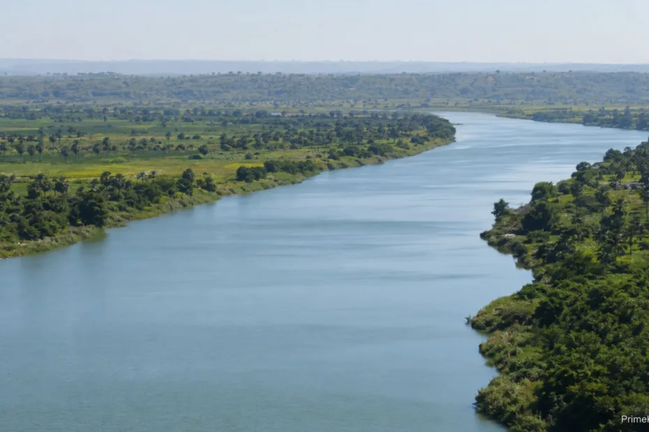 River flows through lush green landscape with calm blue water and distant horizon in the background.